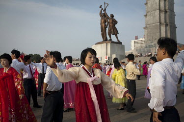 Young people dance in front of the Juche Tower in Pyongyang.