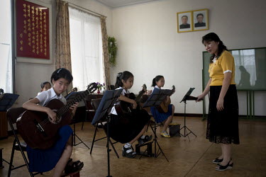 Students play guitars under portraits of the Eternal President Kim Il-sung and Supreme Leader Kim Jong-il in a class at the Schoolchildren's Palace in Pyongyang.