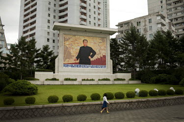 A school girl walks in front of a mural of the Eternal President Kim Il-sung in Pyongyang.