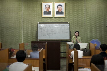 Students study English at the Grand People's Study House in Pyongyang. On the wall are portraits of the Eternal President Kim II-sung (left) and Supreme Leader Kim Jong-iI (right).