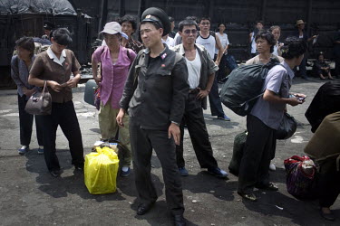 A soldier and other passengers wait for a train at a station near Pyongyang.