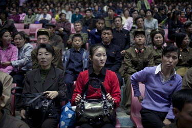 Military sit behind women holding their bags in the crowd at the Arirang Mass Games, a performing arts and gymnastics festival in Pyongyang.