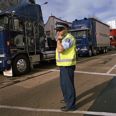 A policeman monitors a truck drivers protest against increased road user charges.