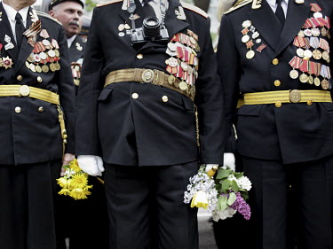 World War II (WW2) veterans wear their medals and hold bunches of flowers as they participate in a parade on Victory Day in Sevastopol.