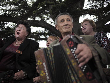 Women sing nostalgic songs as a man plays an accordion on Victory Day in Sevastopol.