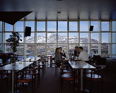 People dine at an expensive restaurant which has a view over the city of Nuuk.