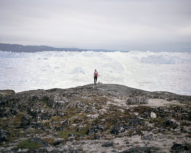 A man participates in an orientation trail near icebergs produced by the Ilulissat Glacier, a UNESCO World Heritage Site.