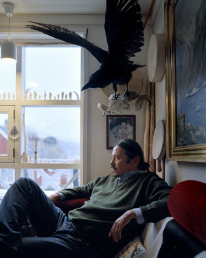 Ole Jorgen Hammeken, explorer and social worker. He sits in his home beneath a stuffed bird.