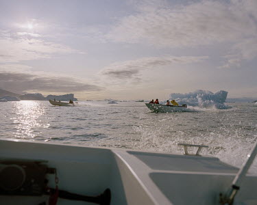 Fishermen pass icebergs as they scout for whales.