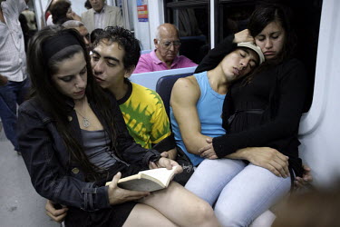 Ceci (left) reads a book as she travels on a bus with Meme and other dancer friends on their way to her mother's house to celebrate her birthday. Ceci works at a restaurant in the El Caminito area of...