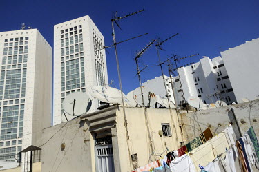 Washing drying on a line, tv aerials and satellite dishes all crowd on a rooftop in the fashionable Maarif district with the towers of the Casablanca Twin Centre rising beyond.