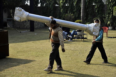 Workers carry a pillar prop at Grewal Farms, one of many wedding reception centres in Amritsar which employs hundreds of staff during the wedding season to work around the clock hosting day and night...