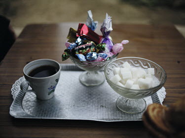 A cup of coffee, sugar and sweets on a tray in a house in Nikita, an unofficial Tatar community.