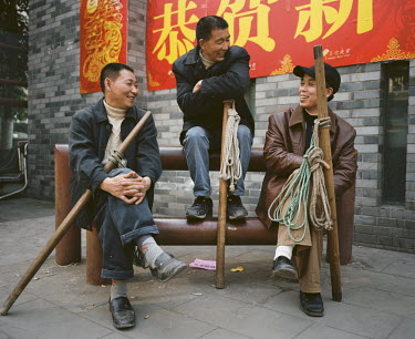 53 year old Yi Bai Quan (centre) and his friends hold their sticks and talk to each other in Chongqing. They are known as 'bang bang men' - people who acts as porters carrying goods all around the cit...