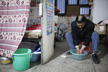 53 year old Yi Bai Quan washes his hands after a day of work at his home in Chongqing. Yi is known as a 'bang bang man' - someone who acts as a porter carrying goods all around the city.