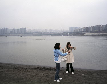 Girls fly kites on the banks of the Yangtze River.
