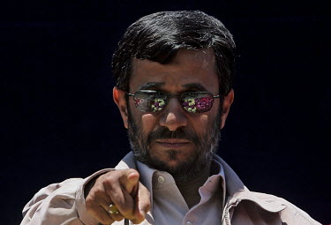 Iranian President Mahmoud Ahmadinejad points at one of his supporters in the crowd, seen partly reflected in his sunglasses, during a speech in the Iranian city of Shiraz.