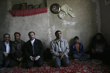 Iranian President Mahmoud Ahmadinejad kneels on the floor with the family of a soldier killed during the Iran-Iraq War. The Iranian President visits these families as part of the programme of one of h...