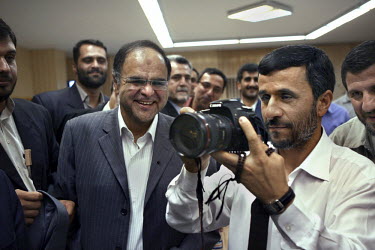 Iranian President Mahmoud Ahmadinejad uses a Canon 20D to take photographs of journalists working at the state-owned IRNA (Islamic Republic News Agency), during Iran's National Journalism Day.