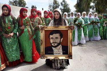 Female Shirazi supporters of the Iranian President Mahmoud Ahmadinejad wait to greet him with the gift of a framed embroidered portrait.