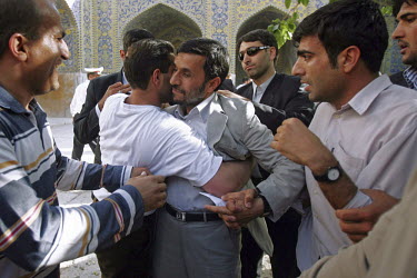 President Mahmoud Ahmdinejad's anxious bodyguard stays close as a supporter embraces the Iranian leader following one of his speeches in the central Iranian town of Isfahan (Esfahan). The bodyguards a...
