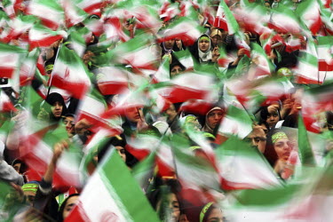 Thousands of schoolgirls and members of the women's Bassiz religious paramilitary wave the Iranian flag on the thirtieth anniversary of the Islamic Revolution in Tehran's central Azadi Square.