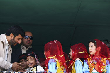 A group of local children, dressed in ethnic uniform, meet the Iranian President Mahmoud Ahmadinejad on his trip to the western province of Kermanshah.