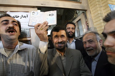 Iranian President Mahmoud Ahmadinejad shows his birth certificate to vote at South Tehran's Bagherzadegan Mosque during elections for the Guardian council.