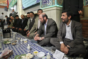 Iranian President Mahmoud Ahmadinejad sits and shares a meal with the families of martyrs from the Iran-Iraq War. These dinners are staples of Ahmadinejad's provinvial visits.