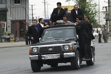 President Mahmoud Ahmadinejad is seen in his armoured Nissan jeep with gun-carrying bodyguards hanging on to all sides of the car, as he is driven to deliver a speech in the central Iranian town of Is...