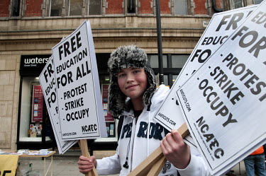 A boy holding placards during a demonstration in central London against the UK government's plans to cut funding for education and raise tuition fees for university students.