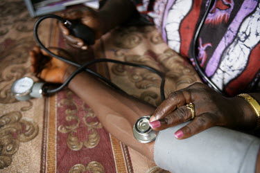 A pregnant woman has her blood pressure taken and pulse listened to by a health worker before she has a rapid HIV test at a clinic in Freetown. The woman is participating in a PMTCT program which aims...