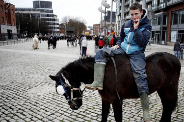 A boy sits on a horse smoking a cigarette at Smithfield horse market in central Dublin. This traditional market has now became a place for people from the poor neighbourhoods who cannot afford to look...