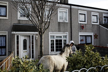 12 year old Luke with his horse outside his home on Belcamp estate.