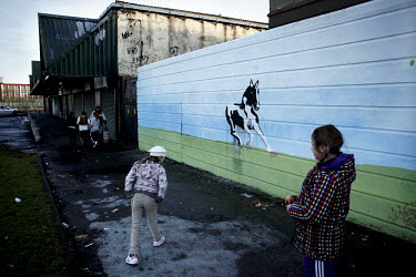 Children walk past a mural of a horse on an estate in Dublin.