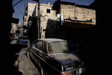A dusty car on a narrow street in Aleppo.
