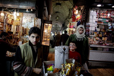 A street seller sells goods to customers at a souk in Aleppo.