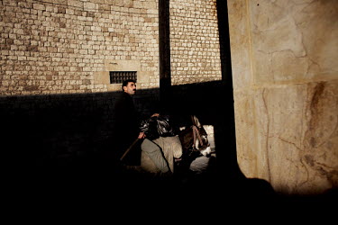 A street seller carries goods as he rides on the back of a donkey at a souk in Aleppo's old town.