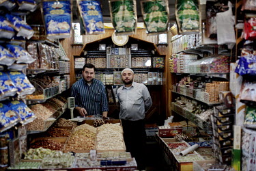 28 year old Ahd Al Rahin Alolaa stands with 32 year old Adnan Hommad in their nuts and sweets shop which they have been running for 10 years at a souk in Aleppo's old town.