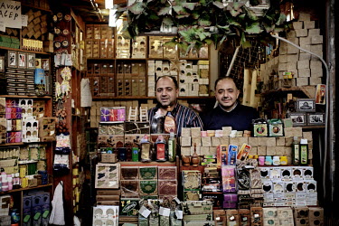 35 year old twins Mohammad Faisal Fadel and Ziad Fadel pose in their traditional soap shop which they have been running together for 20 years at a souk in Aleppo's old town. This shop has existed for...