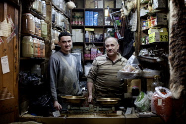 Father and son Abdulbaset Nashed (right) and Ahmed Nashed stand in their spice shop at a souk in Aleppo's old town. This shop has existed for 100 years.