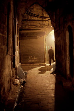 A man walks down an alley at night at a souk in Aleppo's old town. During the day, these narrow streets are filled with people, smells and shops.