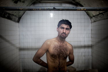 A man poses at a traditional bath, used by locals for hundreds of years. Every evening men arrive for a bath, where they can socialise and smoke.