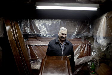 55 year old Hagop Avo poses in his shop at a souk in Aleppo's old town. He has been selling coffins since he stopped working as a taxi driver five years ago.