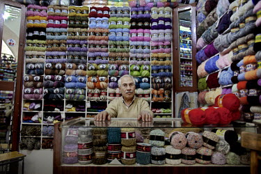 60 year old Ali poses in his knitting yarn shop which he has run for 35 years at a souk in Aleppo's old town.