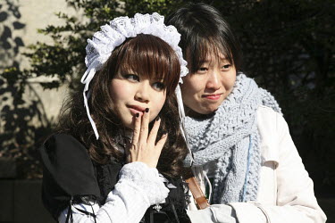 A Japanese girl (left) dressed as Lolita. She visits Harajuku on Sundays to meet friends and have her photo taken by onlookers.