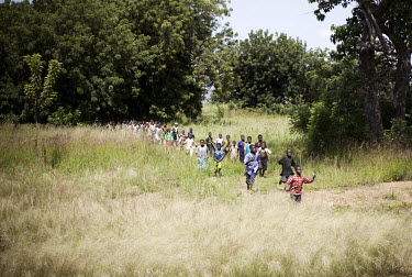 Children run to get a view of the racers during the Tour du Faso cycling race.