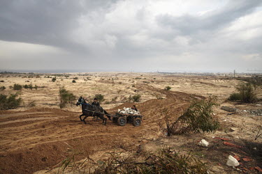 Boys force a horse and cart laden with rubble along a track made by an Israeli tank in Gaza's northern buffer zone with Israel. The buffer zone is a 300 metre wide stretch of land in which dozens have...
