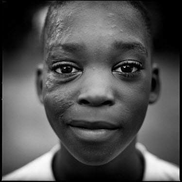 A portrait of a young boy in Joppa, Texas, taken after playing football with his friends.