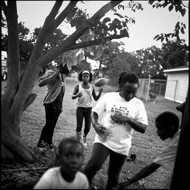 Children play football on a vacant field in Joppa, Texas.